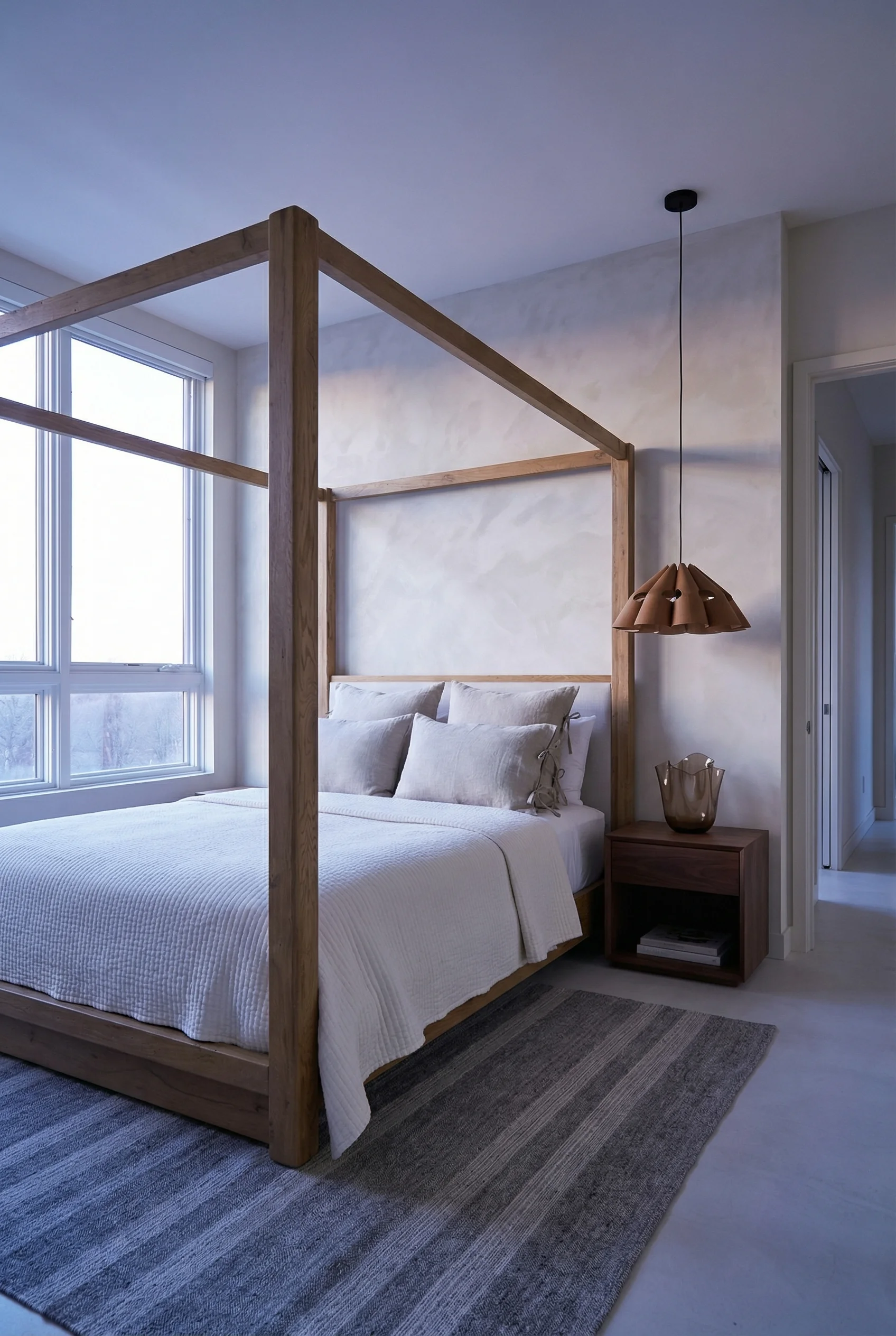 Neutral modern bedroom featuring tan oak canopy bed with limewash walls and ivory coverlet