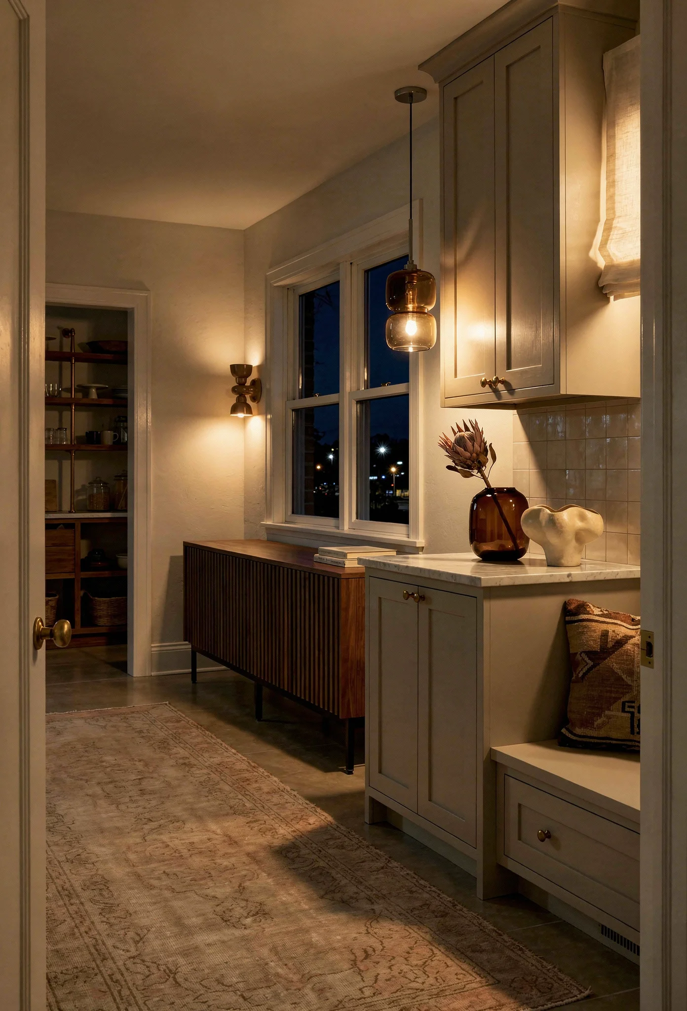 Modern kitchen walnut cabinets evening lighting featuring smoke glass pendant with brass knobs